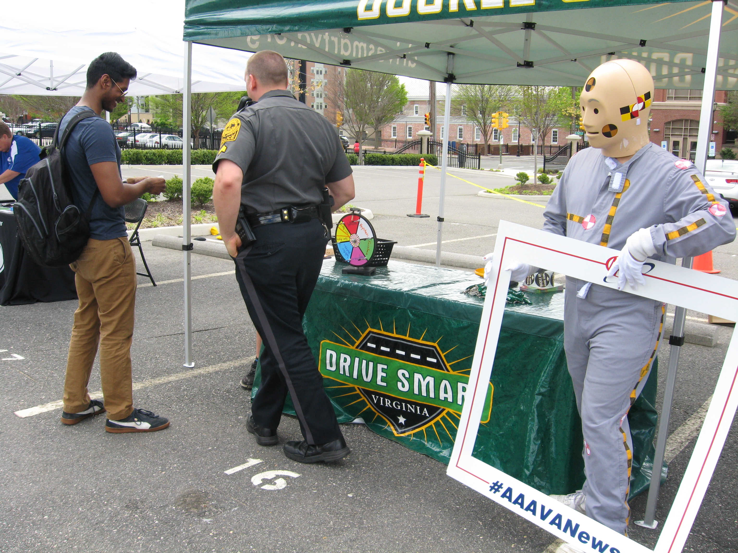 VCU police officer at a drive smart event with student and mannequin in JL lot