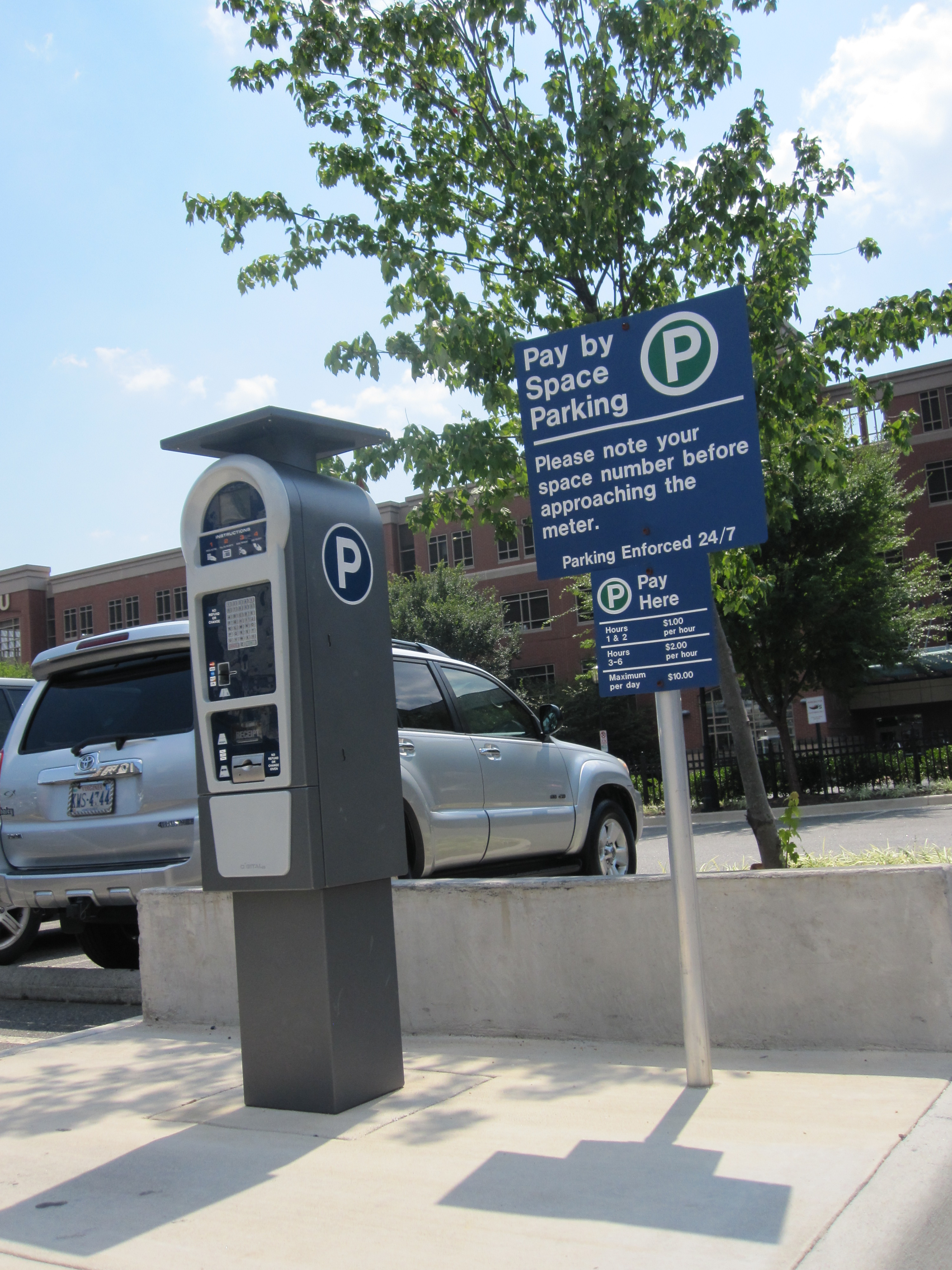 Pay by space parking sign and paystation