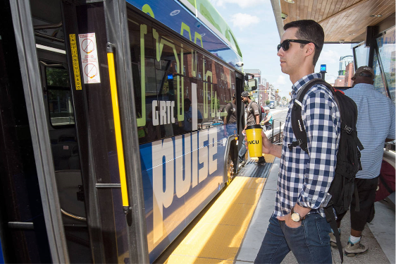 A man boarding a GRTC bus with VCU cup in hand