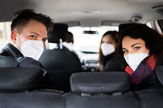 four people carpooling with masks on